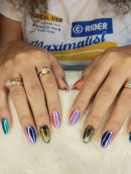 A full view of a stunning multi-chrome and cat eye manicure. Each nail has a unique finish, creating a dynamic and personalized set that reflects the client's style.