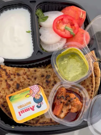My popular Gobhi Paratha thali is a complete meal in itself. It features a generously stuffed paratha served with creamy dahi, a dollop of Amul butter, tangy pickle, and a fresh salad of tomato, cucumber, and onion.