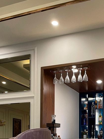 A detail of the bar area, showing the overhead glass rack and the mirrored wall paneling. These elements add functionality and a sense of sparkle to the dining space.