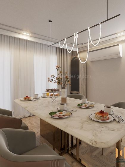 The dining table is set for a meal, showcasing how the space combines everyday function with high-end design, featuring a marble top and modern lighting.