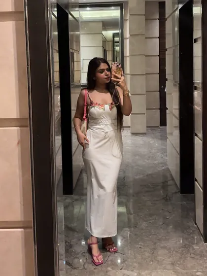 A full-length mirror selfie of the white dress, styled with a pop of pink from the bag and shoes.