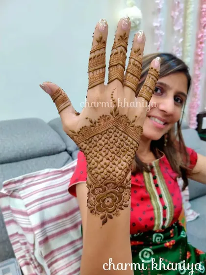 A happy client showing off her beautiful back-of-hand design. The pattern is focused on the wrist and one finger, leaving space for a very modern and clean look.