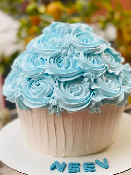 A giant cupcake smash cake, perfect for a fun and messy first birthday photoshoot.