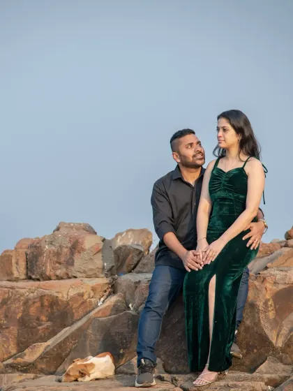 A beautiful pre-wedding portrait on the rocks. The couple's natural pose and the vastness of the sea create a timeless and romantic image.