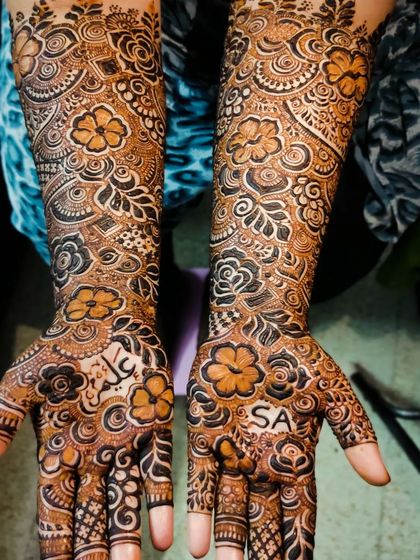 A closer look at a bridal design with personalized names 'Aleem' and 'SA' on the palms.