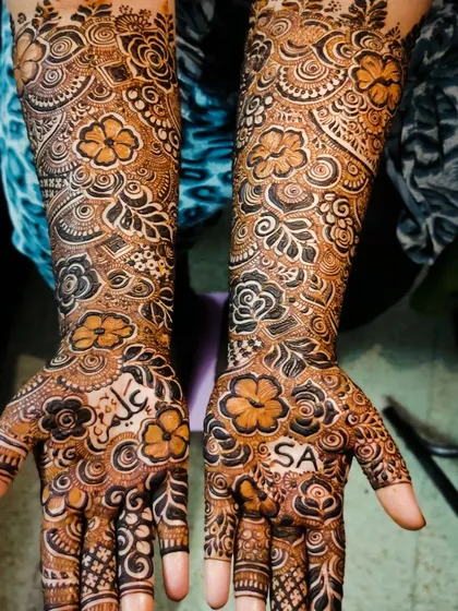 A closer look at a bridal design with personalized names 'Aleem' and 'SA' on the palms.