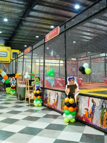 A view of the play area decorated for a Minecraft party. Themed balloon columns and character standees are placed throughout the zone for a cohesive look.