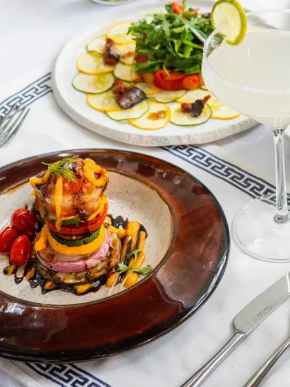 A creative vegetable tower, layered with roasted vegetables and drizzled with a rich sauce. This is one of our vegetarian specialties that is both hearty and elegant.