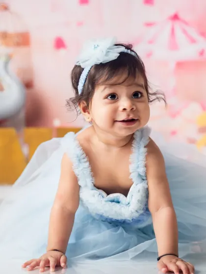 A soft, gentle smile from the birthday girl in her beautiful blue dress. These are the sweet, candid moments we aim to preserve.