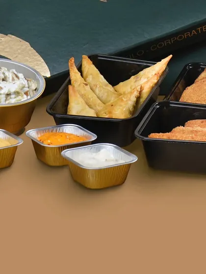 A selection of starters for a bulk order, including crispy samosas, cutlets, and a variety of flavorful dips.