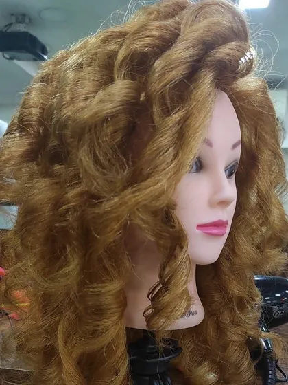 Another angle of the voluminous curls created by one of my students. Practice on mannequins is essential for perfecting these advanced styling techniques.