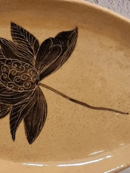 A close-up of my organic oval plate with a hand-painted lotus, showcasing the intricate sgraffito details. This multifunctional piece is perfect for serving or as a decorative accent.