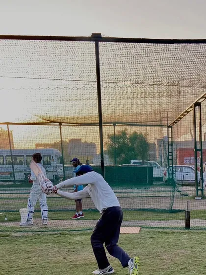 A coach throwing balls during a catching practice session. This is a fundamental part of our daily fielding drills.