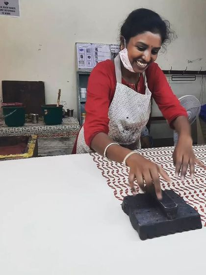 The joy of creation is infectious. A member of our outreach program with the Asha Foundation beams with pride as she masters a new pattern, her smile reflecting the happiness that comes from making something beautiful with her own hands.