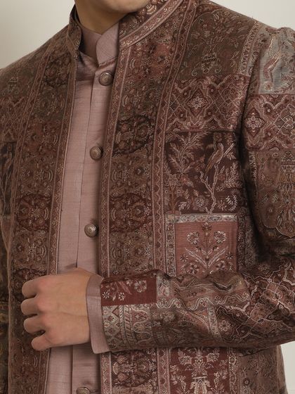 A close-up of the intricate, multi-patterned fabric of our brown Indo-Western jacket. The detail shows our commitment to unique textiles and craftsmanship.