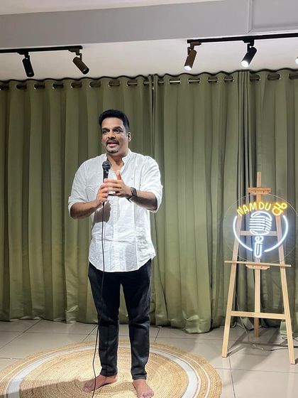 A performer owning the stage during a house-full "Namdu" Kannada stand-up comedy show.