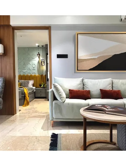 A view from the living room into the master bedroom, revealing a cohesive color story that flows between spaces. The abstract art piece adds a modern touch to the serene environment.