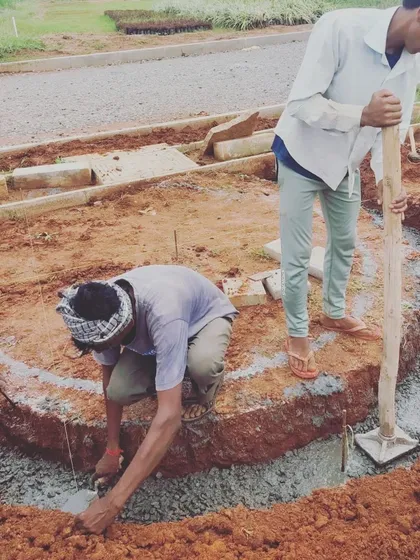 Translating curved lines from a drawing to the physical site is always an exciting moment. Workers carefully construct the foundation for a serpentine path, a key element in this ongoing community park project.