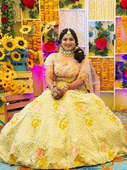 A beautiful portrait of the bride against a backdrop of marigolds. Her makeup is soft and radiant, with a hairstyle adorned with matching flowers.