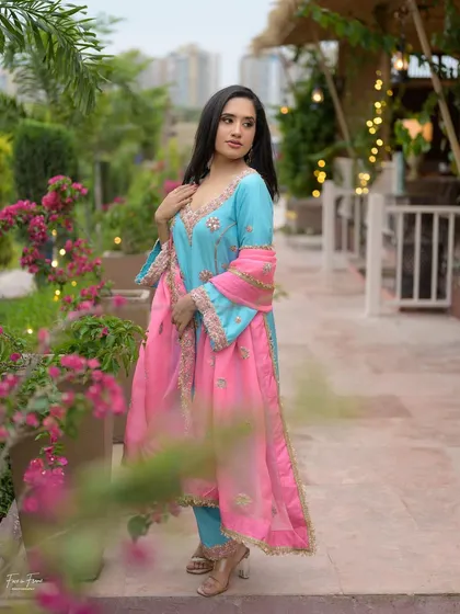 A lovely outdoor portrait. The client is wearing a beautiful blue and pink suit, and her makeup is fresh and natural.