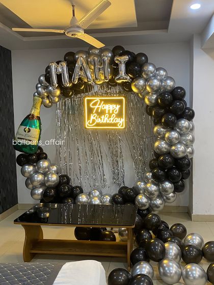 A full view of the black and silver 'MAHI' birthday setup.