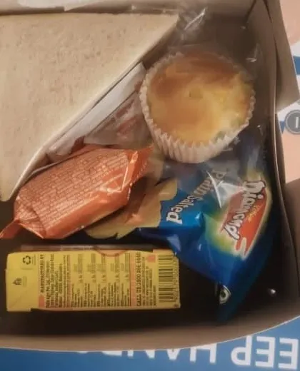 A classic combination for a simple and light snack box. This box includes a triangle sandwich, a muffin, a packet of chips, and a juice box, suitable for morning meetings or school events.