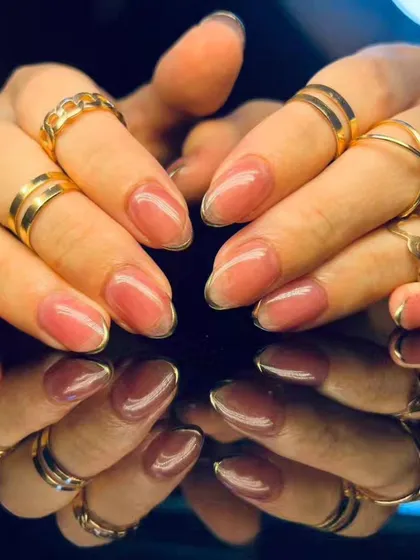 A full view of the elegant shimmery pink and gold outline nails.