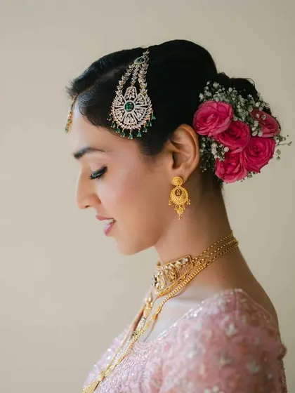 A profile portrait of the bride, adorned with fresh flowers in her hair. The soft lighting and her serene expression make this a delicate and beautiful shot.