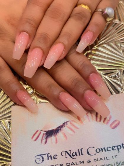 A very long set of coffin nails with a classic pink-to-white ombre effect. This is a dramatic and elegant look that elongates the fingers.