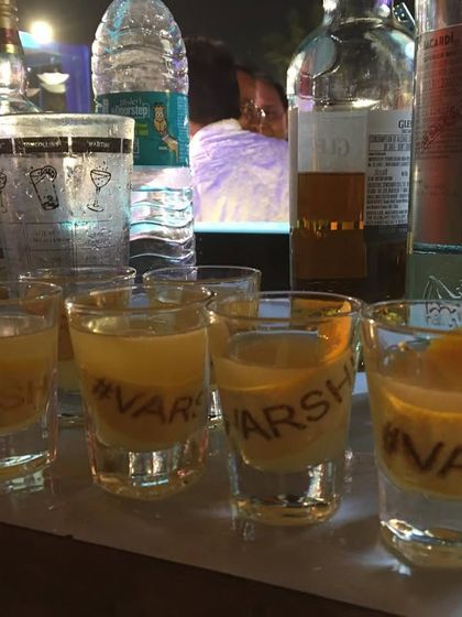 Another look at the personalized shot glasses with the '#VARSHI' wedding hashtag, ready to be served to guests.