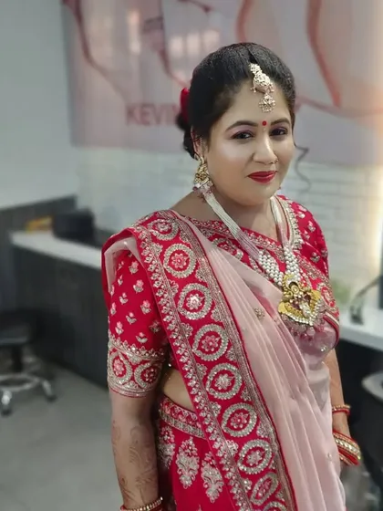 A happy client showing off her finished look in the salon. The makeup is bright and festive, perfect for celebrating.
