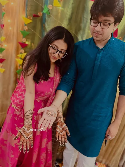 The groom admiring the beautiful initial mehendi on his bride's hand. These little moments are what make it all so special.