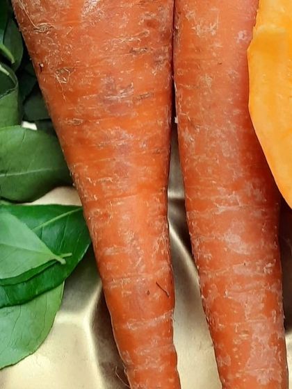 Fresh carrots and curry leaves, side by side. I use carrot puree in my Carrot Turmeric soap for its beta-carotene content, which is great for skin health.