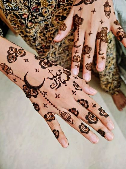 Another angle of the whimsical Eid Mubarak henna design.