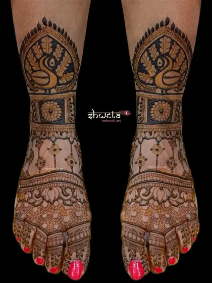 A striking leg design featuring bold peacock motifs. The use of dark-filled areas creates a powerful contrast, making this a standout choice for a bride's feet.