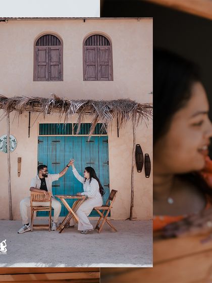 A playful moment captured as a couple high-fives at a cafe table, set against a charming, rustic backdrop.