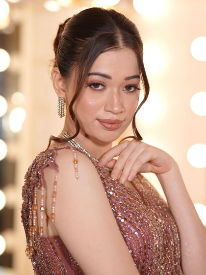 A close-up of a model in a dusty rose gown, featuring a delicate diamond necklace. This look is perfect for a sophisticated evening event.