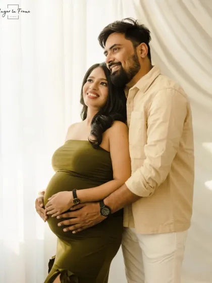 A hopeful and bright maternity portrait. The couple looks towards the light, symbolizing the bright future ahead with their new baby.