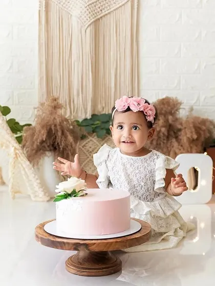 A beautiful first birthday cake smash session with a boho-floral theme, complete with a teepee, flowers, and a simple pink cake. I provide fully styled setups to make these celebrations special.