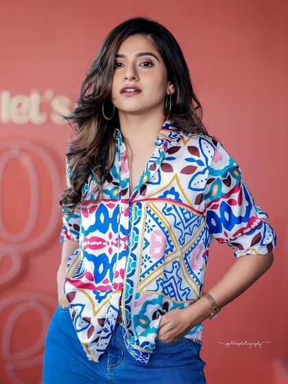 A lifestyle fashion shoot for an actress, featuring a colorful printed shirt and blue jeans. Shot in a modern cafe, these images have a bright, energetic, and youthful feel, perfect for a commercial or social media campaign.