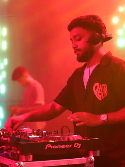 A close-up under red lighting, showing the intensity and passion I bring to every performance. I'm completely locked into the music.