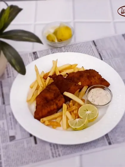 A British classic, done the Wenger's way. This plate features crispy, golden-fried fish fillets served with a generous portion of french fries, tartar sauce, and a wedge of lemon.