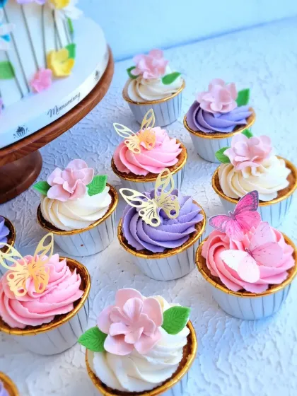 A detailed shot of the floral and butterfly-themed cupcakes, showing the different color combinations and toppers.