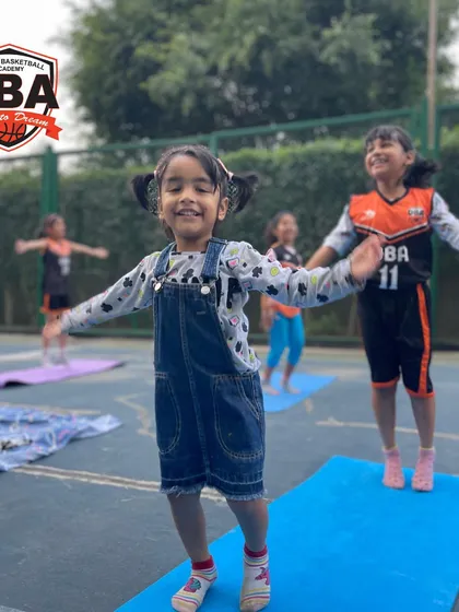 A strong player needs a calm mind. This picture shows the joy and focus during one of our integrated yoga sessions for young athletes, which helps improve their flexibility, balance, and concentration on and off the court.