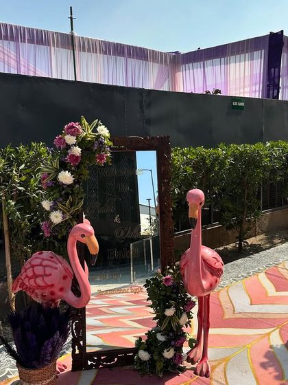 Fun and quirky details like these pink flamingo statues and a decorative mirror made this Haldi carnival even more memorable.