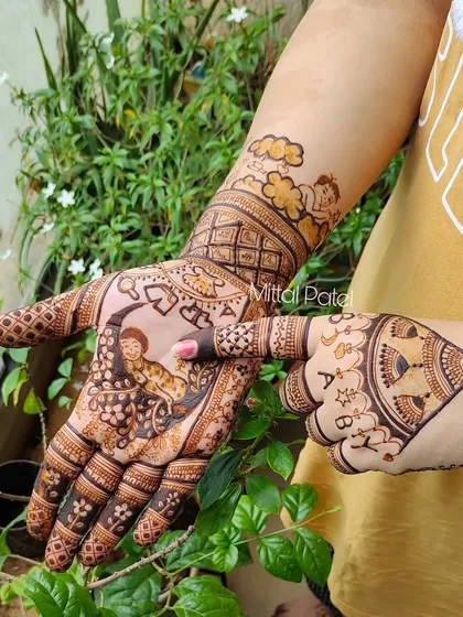 A playful pose showing off a baby shower design. The mehndi features a baby on the moon, angels in the clouds, and the word "BABY" spelled out on the fingers.