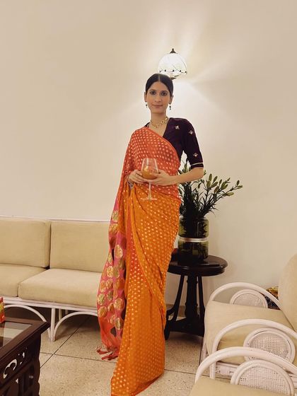 A vibrant orange bandhani sari paired with a contrasting velvet blouse. I love playing with color and texture to create unique festive combinations.