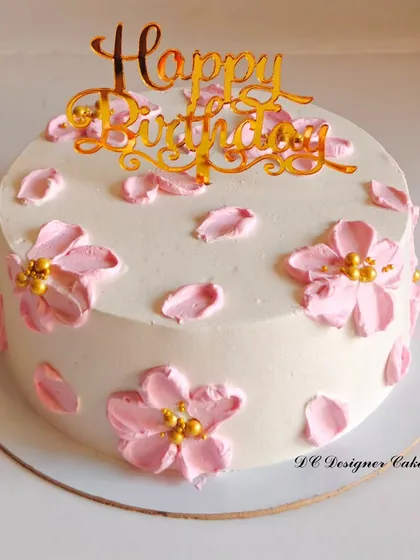 A delicate birthday cake decorated with pink cherry blossoms. The design is inspired by Korean-style cakes, known for their clean and artistic floral work.