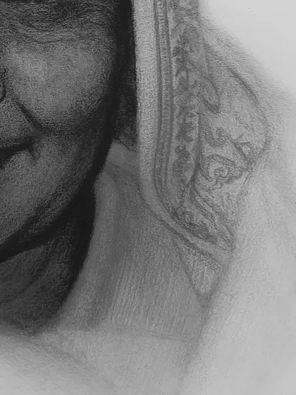 A detail shot focusing on the fabric of the saree and the soft shadows on her neck.
