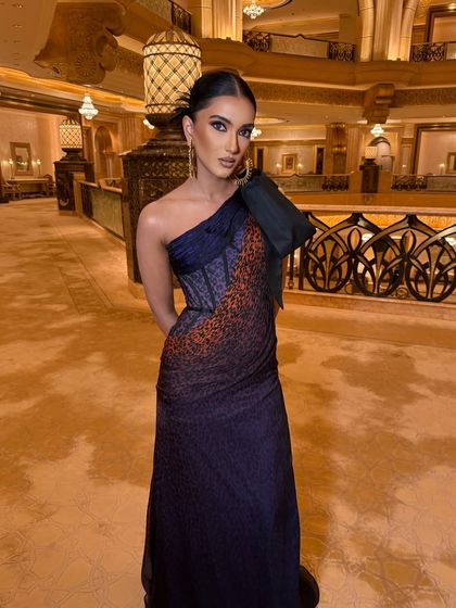 The full view of this stunning one-shoulder gown. The sleek updo and clean makeup ensure the dress remains the hero of the look.